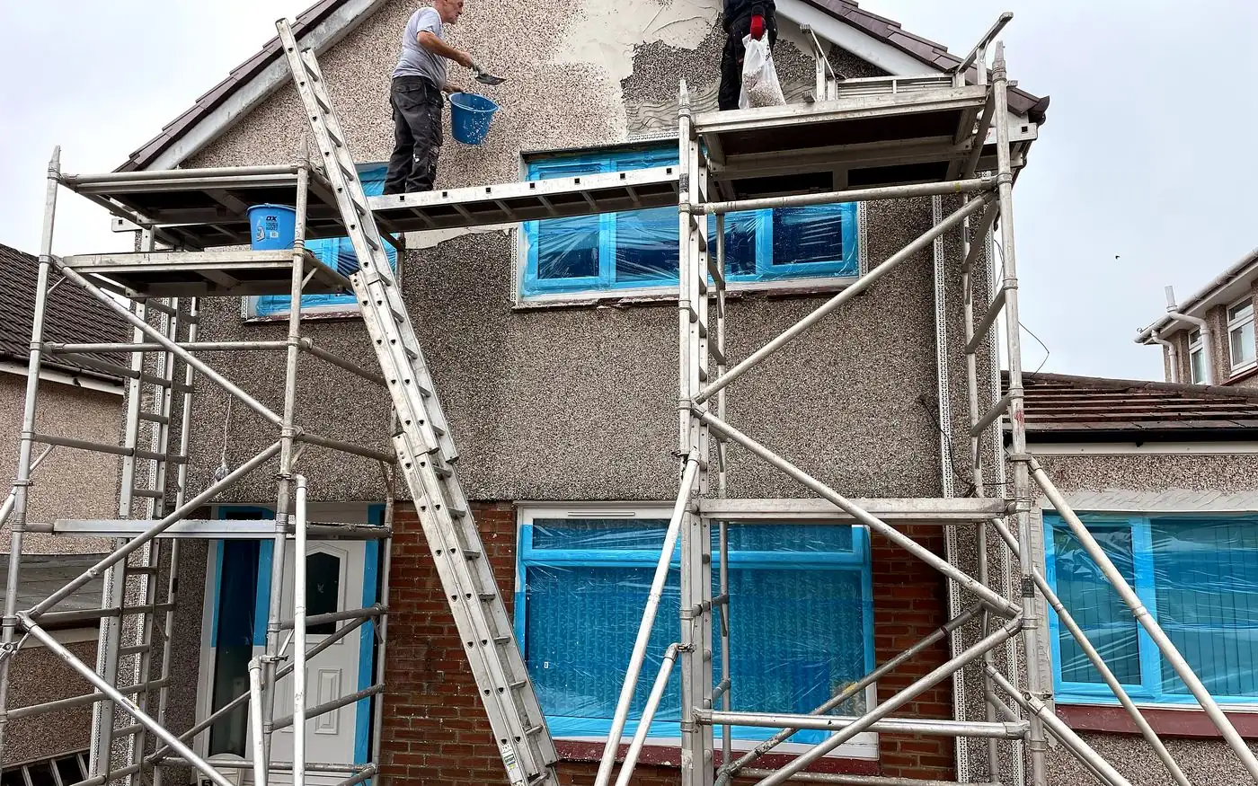 The Jaconelli Builders team roughcasting a two-storey house from scaffolding